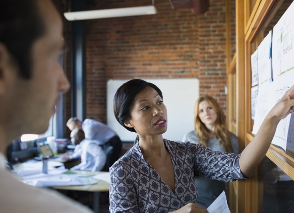 woman gesturing towards board