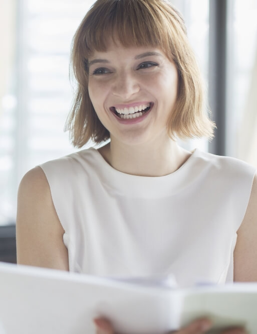 woman smiling holding papers