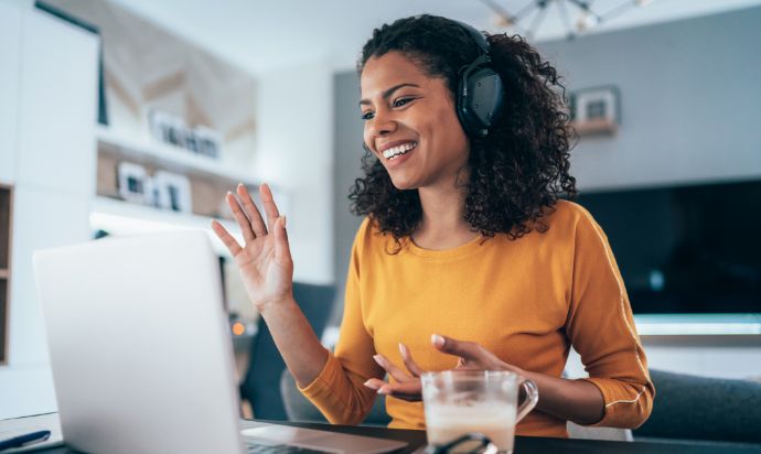 woman waving at laptop screen